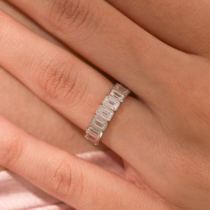 Close-up of white gold Emerald Cut Wedding Band on finger, highlighting the brilliance of the step-cut bezel-set diamonds.