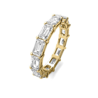 Angled view of yellow gold Emerald Cut Eternity Wedding Band featuring radiant moissanite stones in a continuous setting.