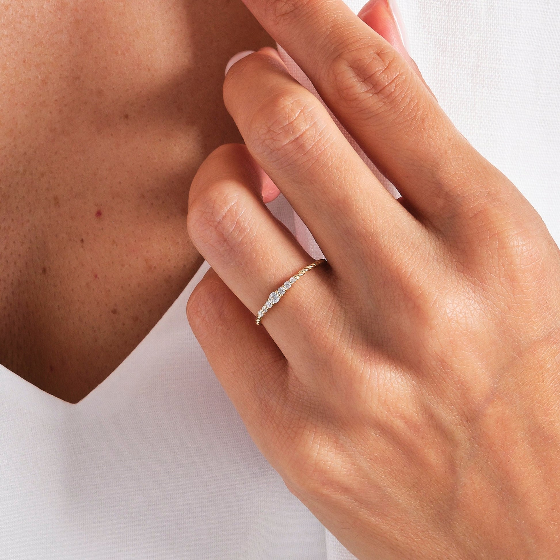 Elegant hand wearing the Seven Stone Twisted Rope Braided Diamond Wedding Ring in yellow gold with round lab diamonds.